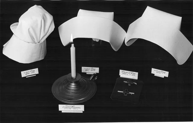 Display of three nursing caps and associated pins, intended to illustrate the capping ceremony.