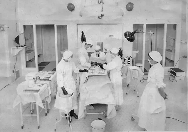 Group of nurses and surgeons work on patient.