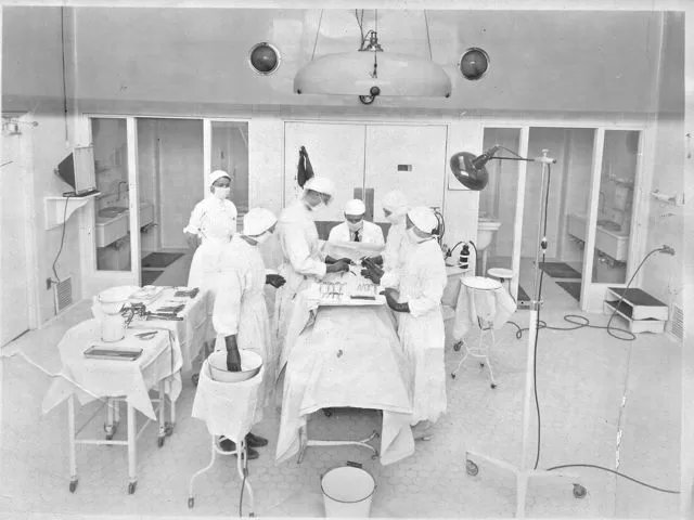 Group of nurses and surgeons work on patient.