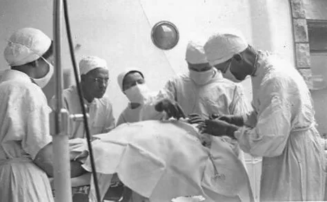 Group of nurses and surgeons work on patient.