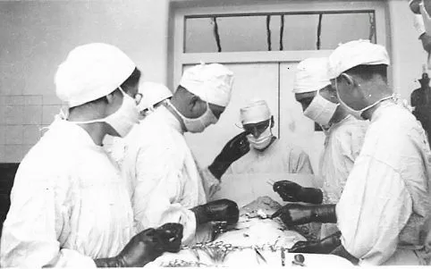 Three surgeons and two nurses surround a patient in VGH O.R.