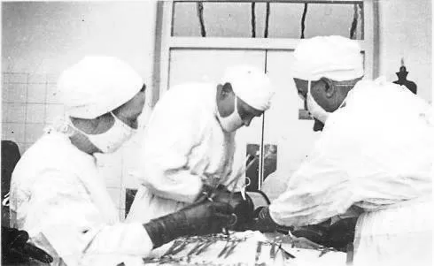 Abdominal operation underway at the VGH O.R. Two surgeons and one nurse pictured with patient.