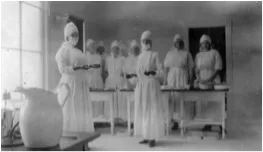 Eight nurses dressed in the operating room gowns of the 1910s.