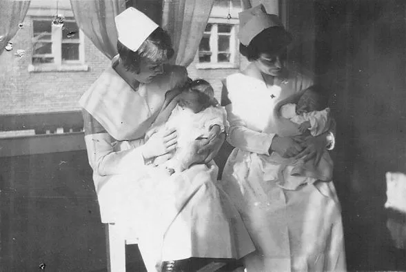 Nurses Olive Diamond and Florence Campbell Clarke hold two infants.