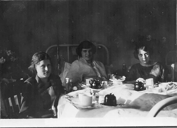 Two visitors seated with a patient.