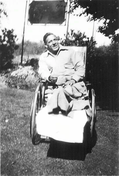 An adult male patient, identity unknown, seated in a wheelchair on the hospital lawn.