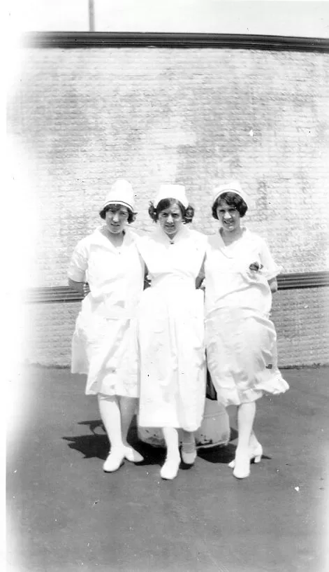 Three student nurses in white.