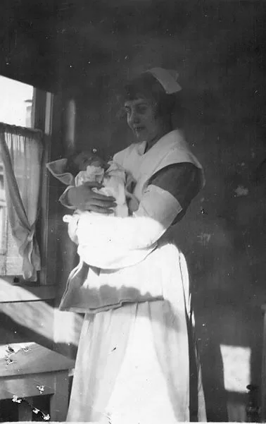 Florence Campbell (Clarke) holding a swaddled infant.