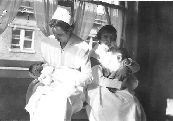 Miss Tretheway and Florence Campbell Clarke sit holding infants.